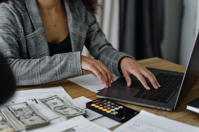 Person performing financial calculations at a desk for fix and flip loans Texas