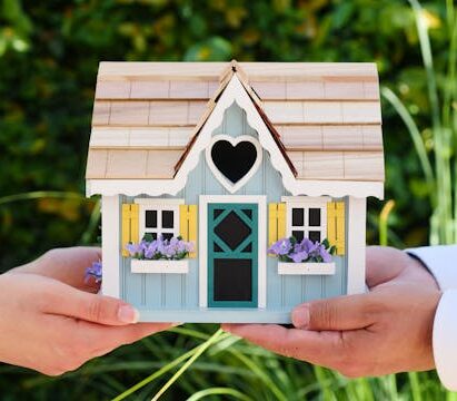 a miniature wooden house exchanging hands for minimum down payment for investment property texas