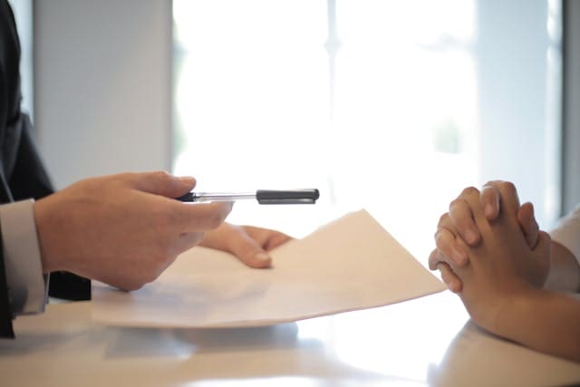 people exchanging paperwork for buying rental property in texas